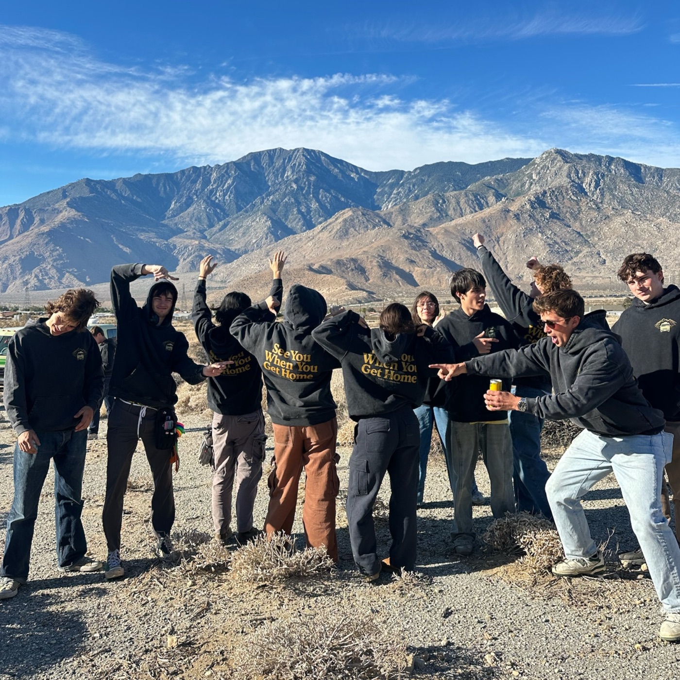 The See You When You Get Home crew posing together in front of the mountains